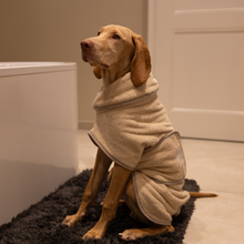Lade das Bild in den Galerie-Viewer, Hundebademantel Cozy Hug von Caruso - OEKO-TEX® zertifiziert - Beige - 6 Größen - Hund sitzt vor Badewanne
